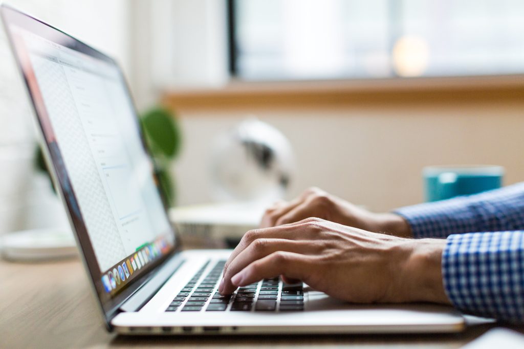 Hands typing on a laptop while building a WordPress website